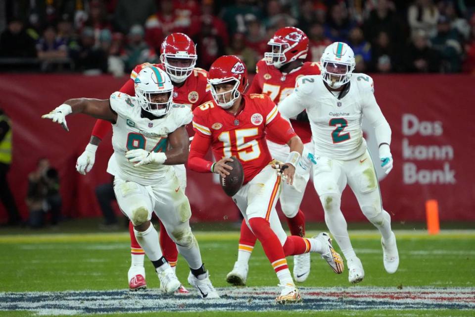 El quarterback de los Chiefs de Kansas City Patrick Mahomes (15) corre con el ovoide ante la marca del defensive tackle Christian Wilkins (izq.) y el linebacker Bradley Chubb, de los Dolphins de Miami, en el partido celebrado el 5 de noviembre de 2023 en Frankfurt, Alemania.