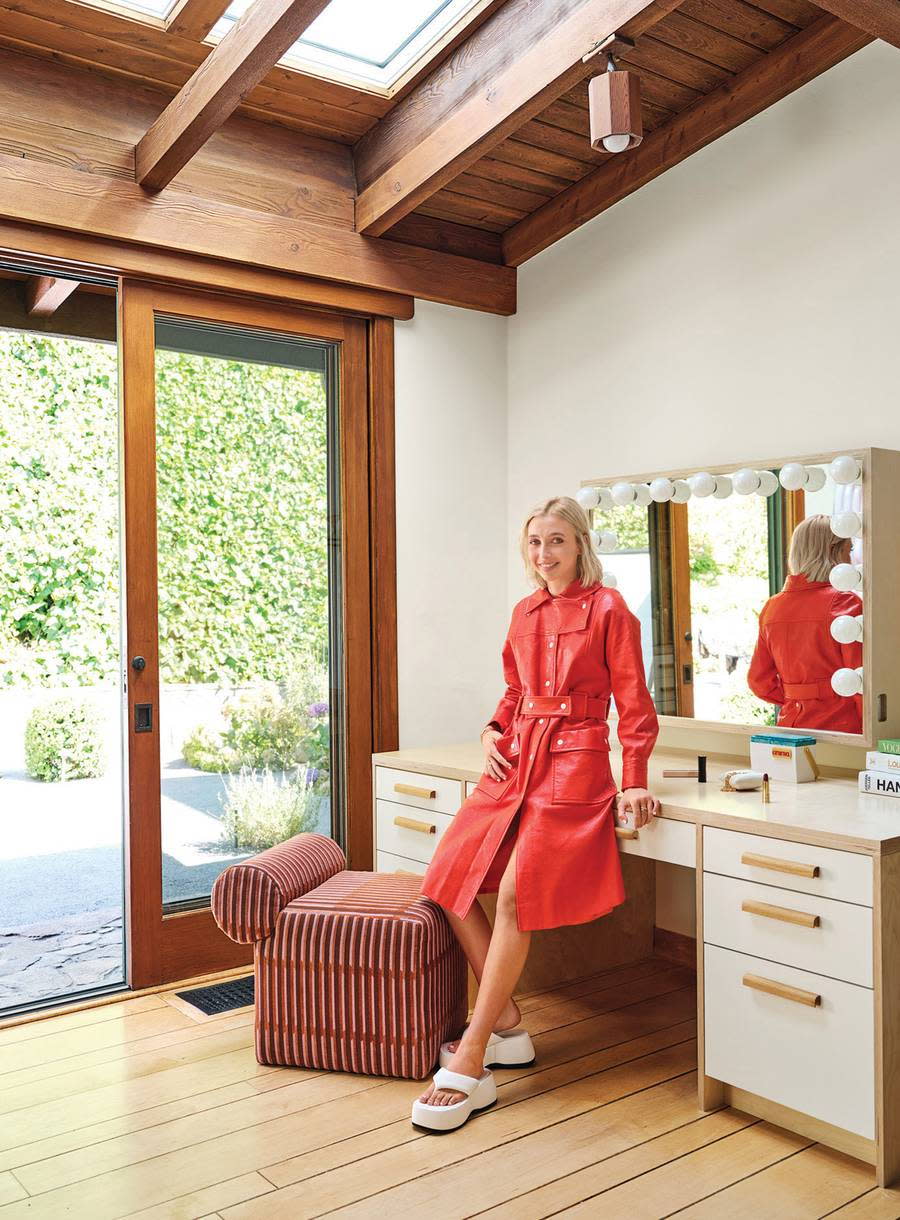 Emma Chamberlain stands near a mirrored dresser in her renovated LA home.