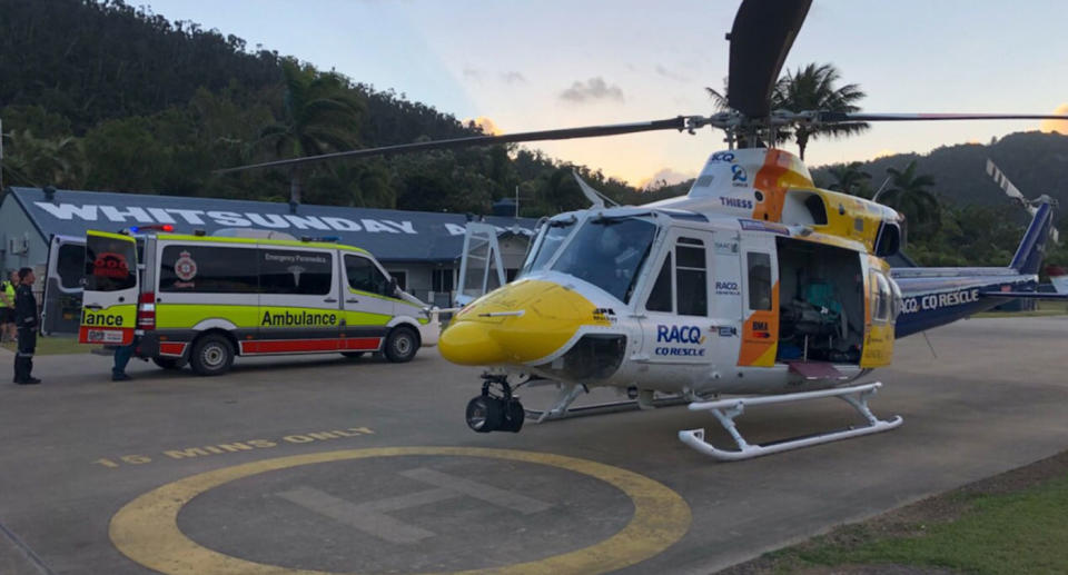 RACQ helicopter pictured at Whitsunday base in Queensland as man injured and pet dog killed by goanna.