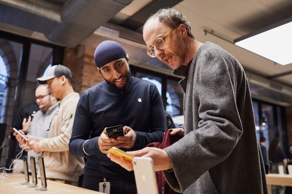 An Apple Store employee with a customer in an Apple Store.