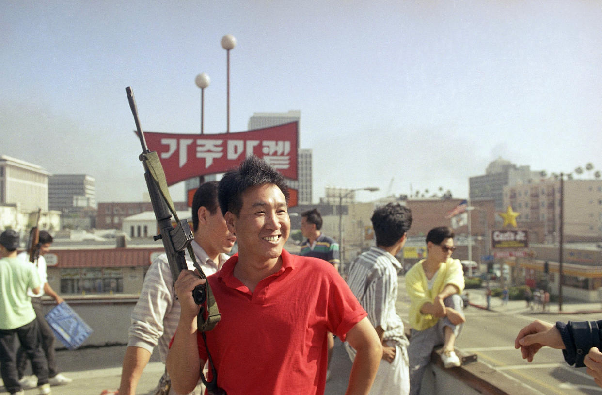 A Korean man carries a weapon to prevent looters from entering a grocery store in Los Angeles on April 30, 1992. (John Gaps III / AP)