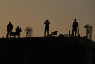 Pakistan police commandos stand guard on a rooftop while they observe the area to ensure the security of the rally of Pakistan's former Prime Minister Imran Khan's 'Pakistan Tehreek-e-Insaf' party, in Rawalpindi, Pakistan, Saturday, Nov. 26, 2022. Khan said Saturday his party was quitting the country's regional and national assemblies, as he made his first public appearance since being wounded in a gun attack earlier this month. (AP Photo/Anjum Naveed)