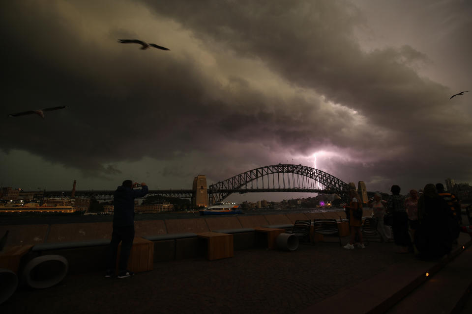 A lightning bolt strikes as a storm cell is seen above the Sydney Harbour Bridge in Sydney, Saturday, October 20, 2018. 