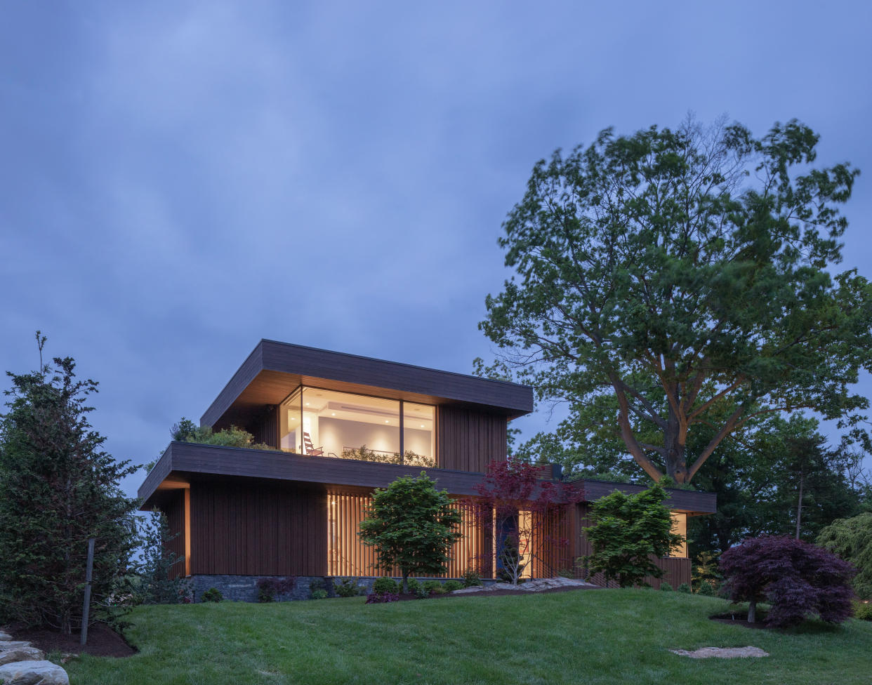  Exterior shot of a modern home with large windows at dusk 