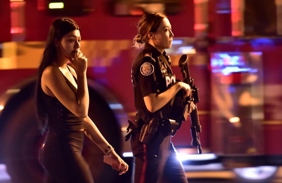 <p>A police officer escorts a civilian away from the scene of a shooting, Sunday, July 22, 2018, in Toronto. (Photo: Frank Gunn/The Canadian Press via AP) </p>