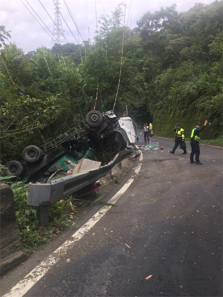 大貨車打滑擦撞左側護欄翻覆滑落邊坡上。（圖／民視新聞翻攝）