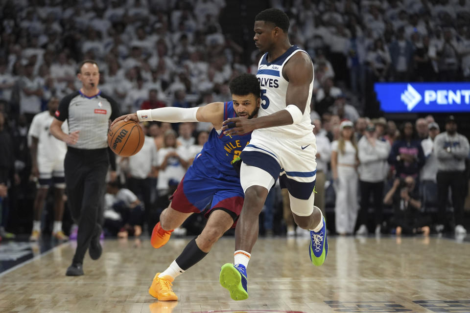 Denver Nuggets guard Jamal Murray, front left, works toward the basket as Minnesota Timberwolves guard Anthony Edwards, right, defends during the first half of Game 3 of an NBA basketball second-round playoff series, Friday, May 10, 2024, in Minneapolis. (AP Photo/Abbie Parr)
