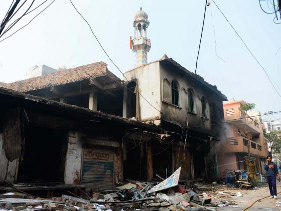 Flags can be seen on the burnt-out mosque’s minaret in the Ashok Nagar neighbourhood (AFP/Getty)