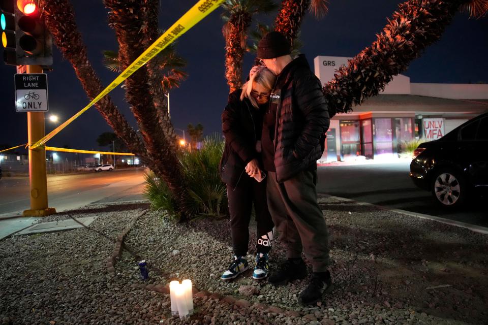 Sean Hathcock, right, kisses Michelle Ashley after the two left candles for victims of a shooting at the University of Nevada, Las Vegas, Wednesday, Dec. 6, 2023, in Las Vegas. The two graduated from the school and live nearby.