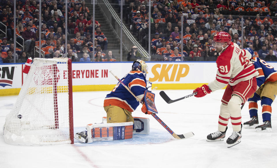 Calgary Flames' Nazem Kadri (91) scores against Edmonton Oilers goalie Stuart Skinner, left, during first-period NHL hockey game action in Edmonton, Alberta, Saturday, Feb. 24, 2024. (Jason Franson/The Canadian Press via AP)