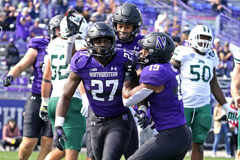 Northwestern running back Anthony Tyus III, left, celebrates with wide receiver Jacob Gill, right, and wide receiver Genson Hooper Price after he scored a touchdown during the second half of an NCAA college football game in Evanston, Ill., Saturday, Sept. 25, 2021. Northwestern won 35-6. (AP Photo/Nam Y. Huh)