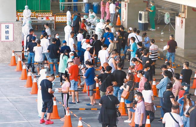 本土新冠肺炎疫情再度升溫，北市環南市場3日設置篩檢站，攤商與工作人員排隊等候檢測。（趙雙傑攝）