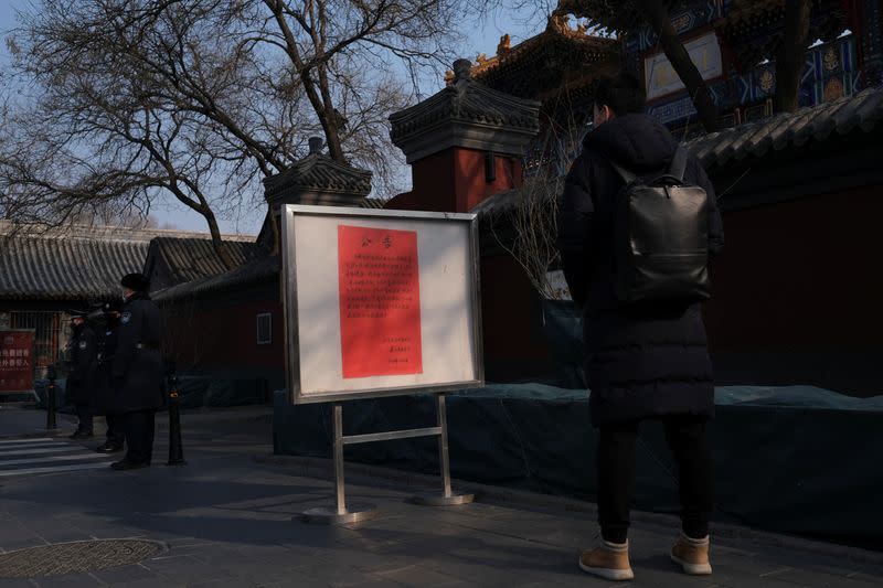 A man looks at a notice saying that the temple is closed for the safety concern following the outbreak of a new coronavirus, outside Lama Temple in Beijing