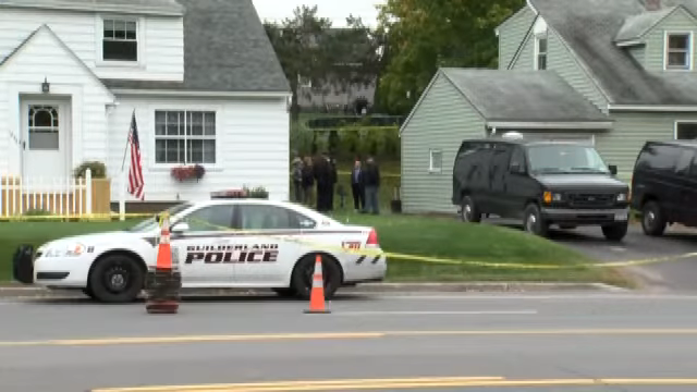 police car and black vans outside of the home