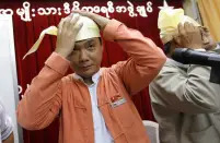 FILE PHOTO: Elected candidate Thaw and counterparts try on Myanmar's traditional cap at NLD head office in Yangon