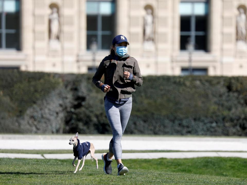 A jogger with her dog in the Tuileries Garden in Paris amid the coronavirus lockdown in France, 23 March, 2020: Reuters