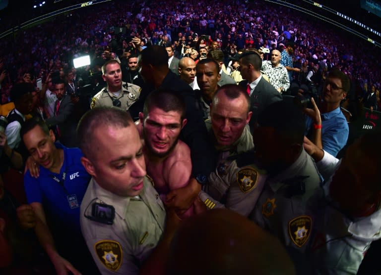 Security escorts Khabib Nurmagomedov out of T-Mobile arena amid the chaos that followed his UFC 229 victory over Conor McGregor