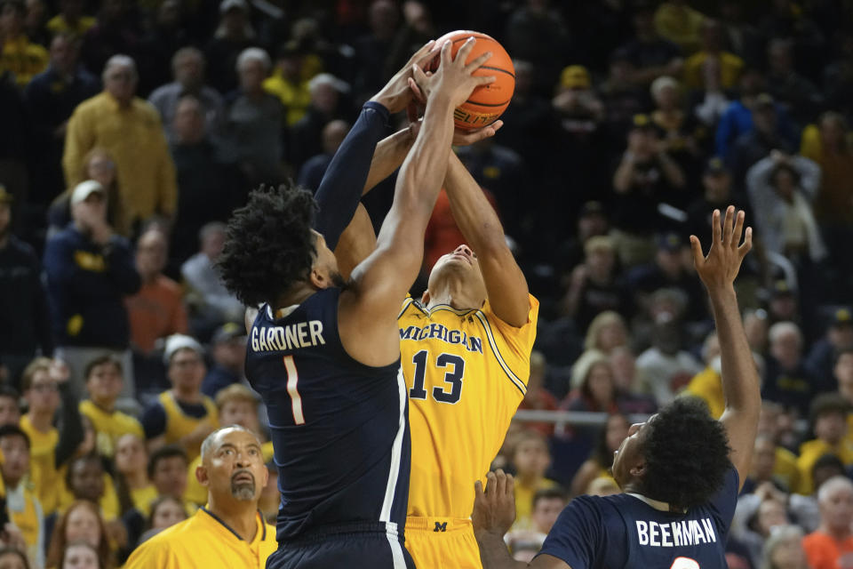 Virginia forward Jayden Gardner (1) blocks Michigan guard Jett Howard's (13) shot in the second half of an NCAA college basketball game in Ann Arbor, Mich., Tuesday, Nov. 29, 2022. (AP Photo/Paul Sancya)