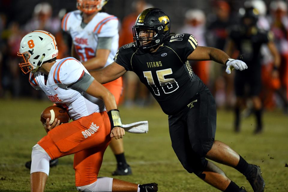 Treasure Coast High School's Christin Ware-Terry (15) chases down Boone High School quarterback Casey St. John on Friday, Nov. 19, 2021, during a Region 2-8A semifinal playoff game at the South County Regional Stadium in Port St. Lucie. The titans won 51-19 to extend their season to the regional final.