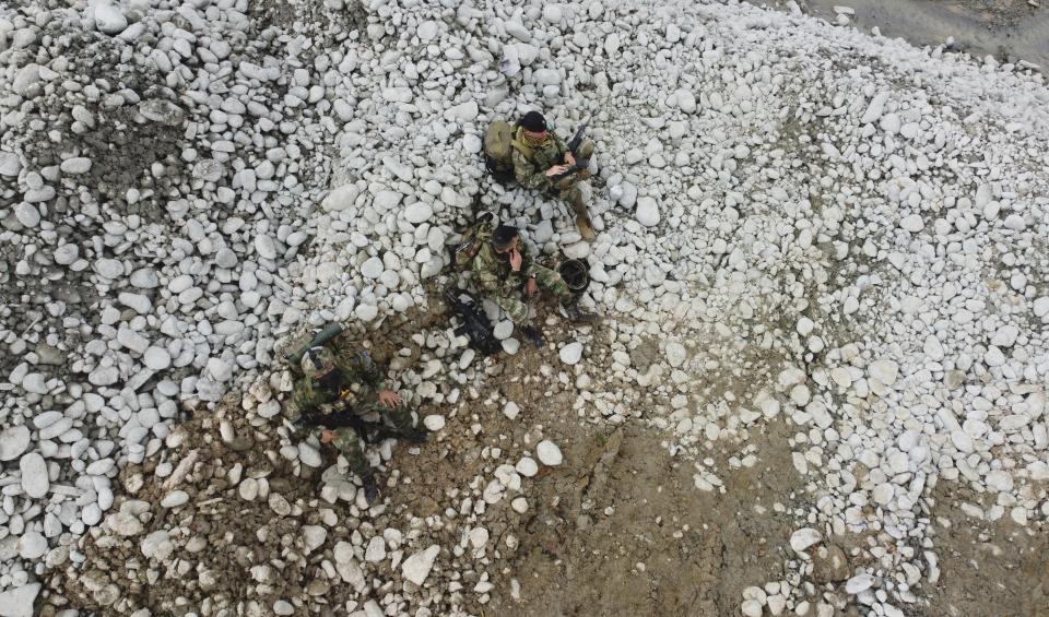 Soldiers rest momentarily as they work with the National Police to destroy an illegal gold mining operation as part of the Armed Forces' "Operation Guamuez III" in Magui Payan, Colombia, Tuesday, April 20, 2021. Illegal gold mining is common in Colombia, especially wildcat mines in poverty-stricken areas dominated by criminal gangs with little state presence. (AP Photo/Fernando Vergara)