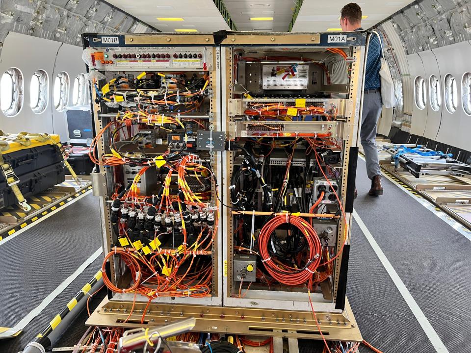 An instrumentation rack with lots of wires and cables hanging out on board a wide-body Boeing 777-9 testbed