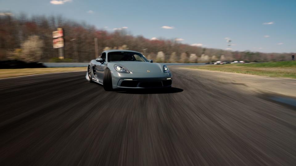 a silver sports car driving on a road