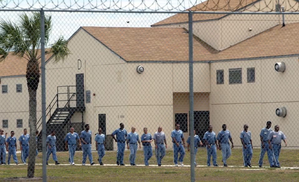 Inmates file past as they head to a food service building for lunch at the Hendry Correctional Institution Wednesday, April 11, 2007 in Immokalee, Fla.
