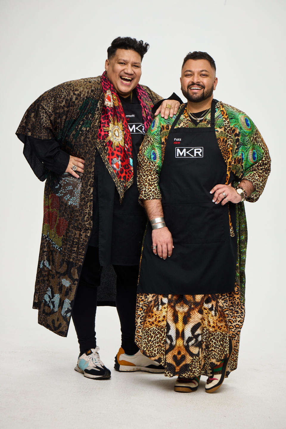 MKR 2022 contestants Arrnott and Fuzz from Sydney stand laughing in MKR aprons