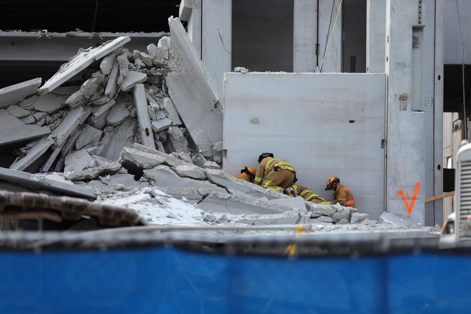DORAL, FL - OCTOBER 10: Miami-Dade Rescue workers prepare to pull a body out of the rubble of a four-story parking garage that was under construction and collapsed at the Miami Dade College’s West Campus on October 10, 2012 in Doral, Florida. Early reports indicate that one person was killed in the collapse, at least seven people injured and one person may still be trapped in the rubble. (Photo by Joe Raedle/Getty Images)