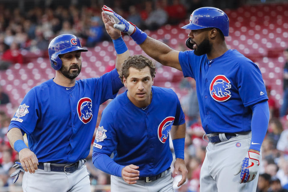 Chicago Cubs' Albert Almora Jr., center, and Daniel Descalso, left, celebrate with Jason Heyward, right, after scoring on a two-run double by Kyle Hendricks off Cincinnati Reds starting pitcher Tanner Roark during the second inning of a baseball game Tuesday, May 14, 2019, in Cincinnati. (AP Photo/John Minchillo)