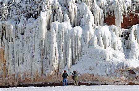 Sightseers look at a frozen rock face along the Apostle Islands National Lakeshore of Lake Superior, the world's largest freshwater lake, near Cornucopia, Wisconsin February 14, 2014. REUTERS/Eric Miller