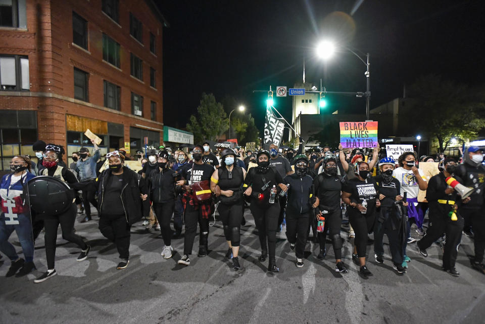 Demonstrators march along a street in Rochester, N.Y., Friday, Sept. 4, 2020, during a protest over the death of Daniel Prude. Prude apparently stopped breathing as police in Rochester were restraining him in March 2020 and died when he was taken off life support a week later. (AP Photo/Adrian Kraus)