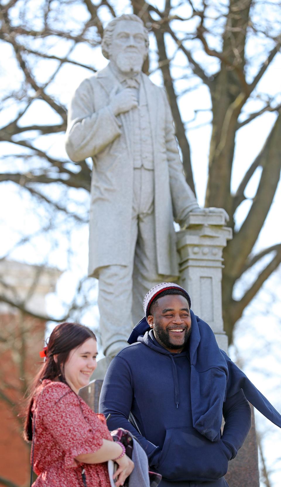 Ohio Innocence Project's newest freed client Michael Sutton receives a tour of the University of Akron campus from students as a statue of John R. Buchtel appears to look on, Wednesday, March 1, 2023, in Akron, Ohio.