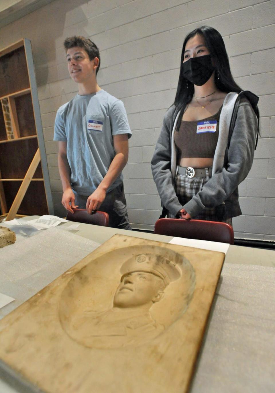 North Quincy High School sophomore docents Oliver Smith, left, and Sabrina Leung explain how granite sculptors used carving guides Friday, April 29, 2022.