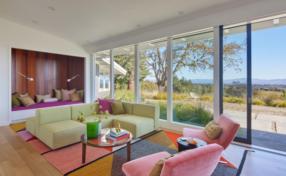 A living room with pastel furniture and rug