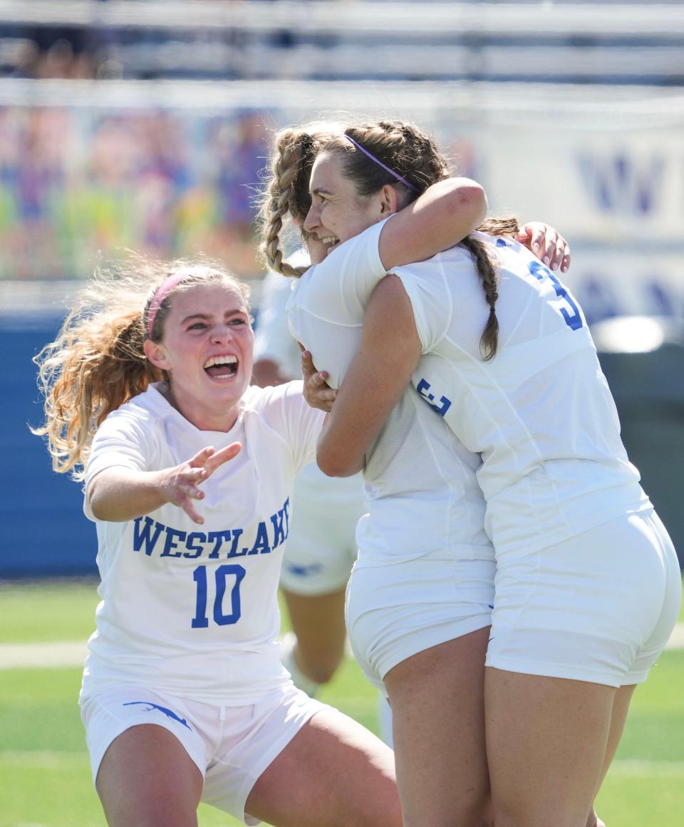 Westlake teammates Carter Utkov, left and Kate Grannis, right, hug AJ Carlson after the midfielder's game-winning goal against Rockwall in the Class 6A state semifinals. Westlake won 1-0.