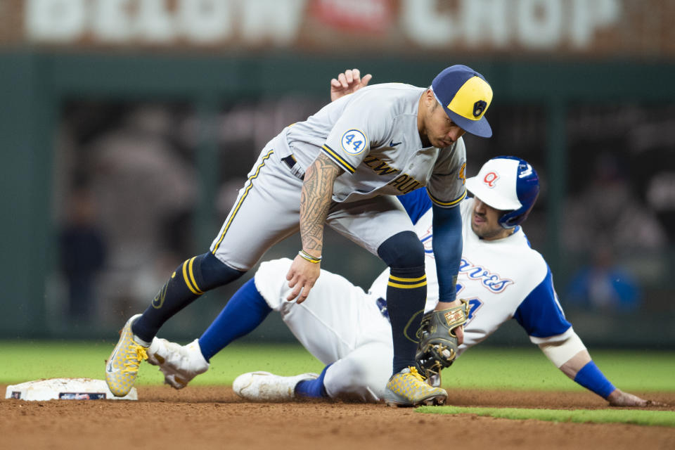 Milwaukee Brewers second baseman Kolten Wong, top, tags out Atlanta Braves' Adam Duvall (14) during the eighth inning of a baseball game Saturday, May 7, 2022, in Atlanta. (AP Photo/Hakim Wright Sr)