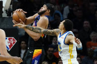 Phoenix Suns center JaVale McGee shoots as Golden State Warriors forward Juan Toscano-Anderson, right, defends during the first half of an NBA basketball game, Tuesday, Nov. 30, 2021, in Phoenix. (AP Photo/Matt York)