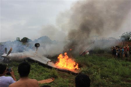 People look at a Fairchild Swearingen Metroliner aircraft of Bolivian airliner AEROCON that crashed on its approach to the Riberalta airport in the Beni Province, November 3, 2013. Eight persons were killed and nine injured, according to local media report. REUTERS/ABI/Bolivian Presidency/Handout