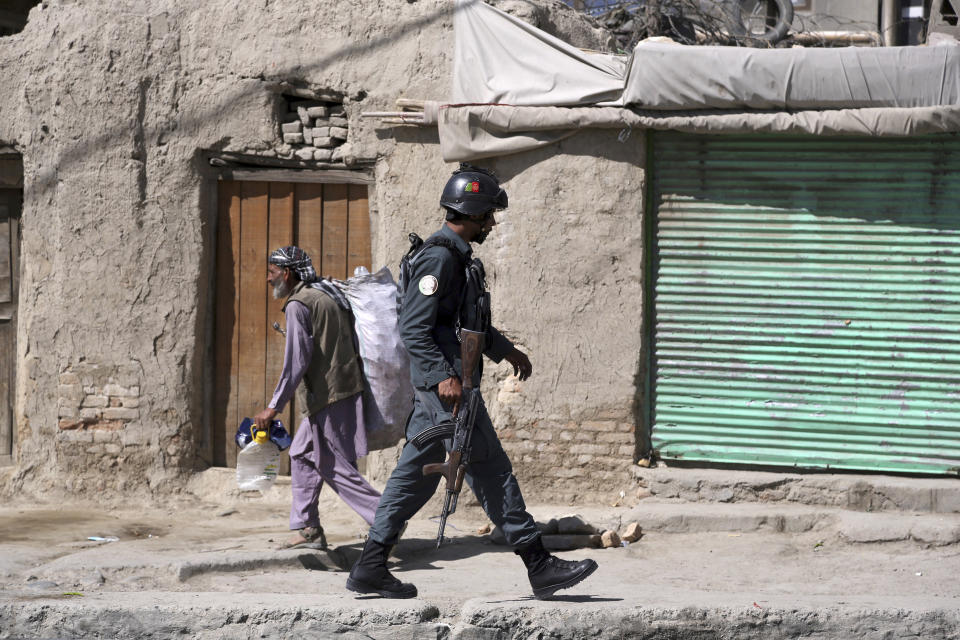 An Afghan security officer arrives at an area near a house where attackers are hiding, in Kabul, Afghanistan, Tuesday, Aug. 21, 2018. Afghan police say the Taliban fired rockets toward the presidential palace in Kabul as President Ashraf Ghani was giving his holiday message for the Muslim celebrations of Eid al-Adha. (AP Photo/Rahmat Gul)