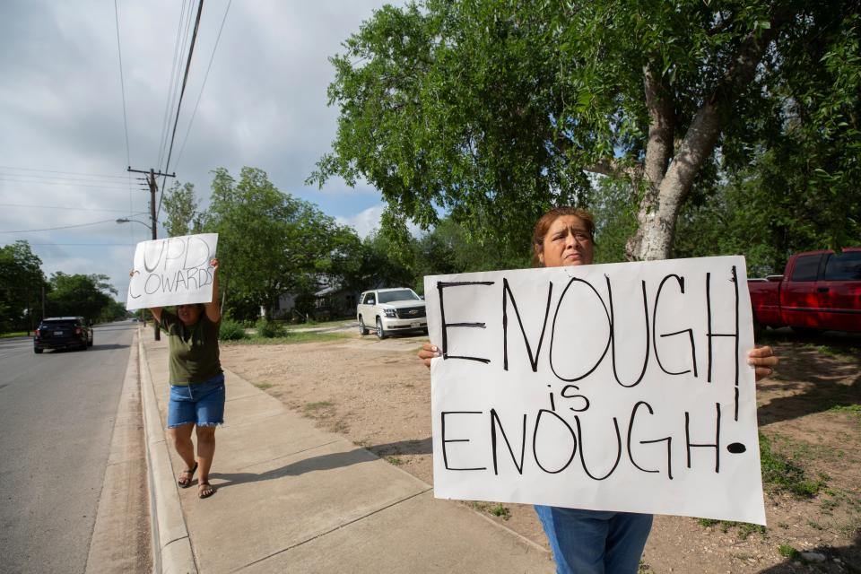 Residents of Uvalde, Texas hold signs calling Uvalde Police Department “cowards” as frustration grows in the community in response to how a shooting was handled after 19 children and two adults were murder at Robb Elementary School in Uvalde, Texas on May 29, 2022. 