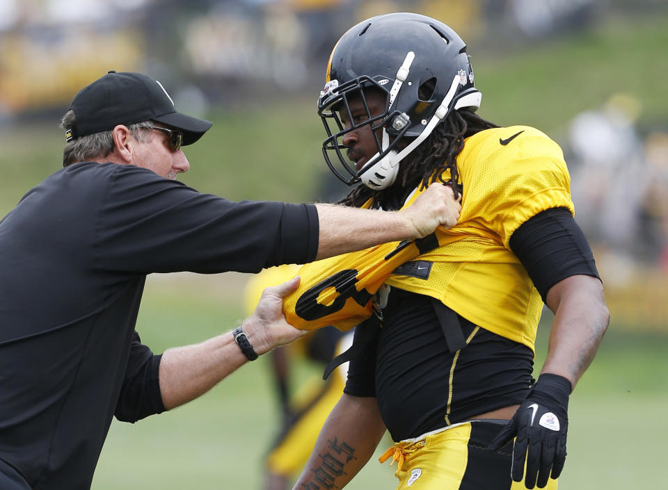 FILE - Pittsburgh Steelers linebacker Jarvis Jones, right, gets some hands-on instruction from linebackers coach Keith Butler during NFL football training camp in Latrobe, Pa., July 31, 2013. Butler retired as the team's defensive coordinator on Saturday, Jan. 22, less than a week after his 19th season with the team ended in a blowout playoff loss to Kansas City. The 65-year-old Butler, who spent 10 seasons as a linebacker for the Seattle Seahawks in the 1970s and 80s before getting into coaching, helped the Steelers win two Super Bowls and reach another during his nearly two decades with the team. (AP Photo/Keith Srakocic, File)