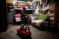 Huan feeds her son Peijun in her family's hut at a recycling yard at the edge of Beijing, China, October 20, 2016. REUTERS/Thomas Peter/Files