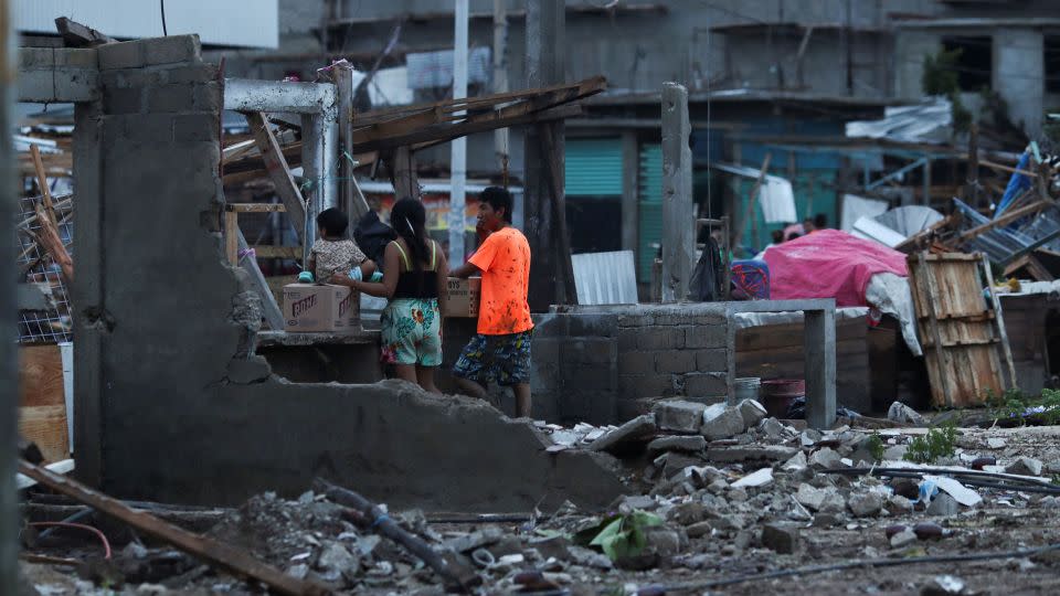 People stand near street stalls damaged by Hurricane Otis near the entrance to Acapulco, in the Mexican state of Guerrero, Mexico October 25, 2023. - Henry Romero/Reuters