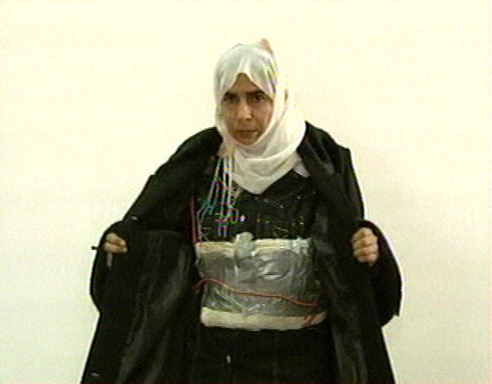 FILE - This Nov. 13, 2005 file photo made from television shows Iraqi Sajida al-Rishawi opens her jacket and shows an explosive belt as she confesses on Jordanian state-run television to her failed bid to set off an explosives belt inside one of the three Amman hotels targeted by al-Qaida. Al-Rishawi, was sentenced to death. In January 2015, almost a decade later, she has emerged as a potential bargaining chip in negotiations over Japanese hostages held by the Islamic State group, the successor of al-Qaida in Iraq, which orchestrated the Jordan attack. (AP Photo/Jordanian TV, File)