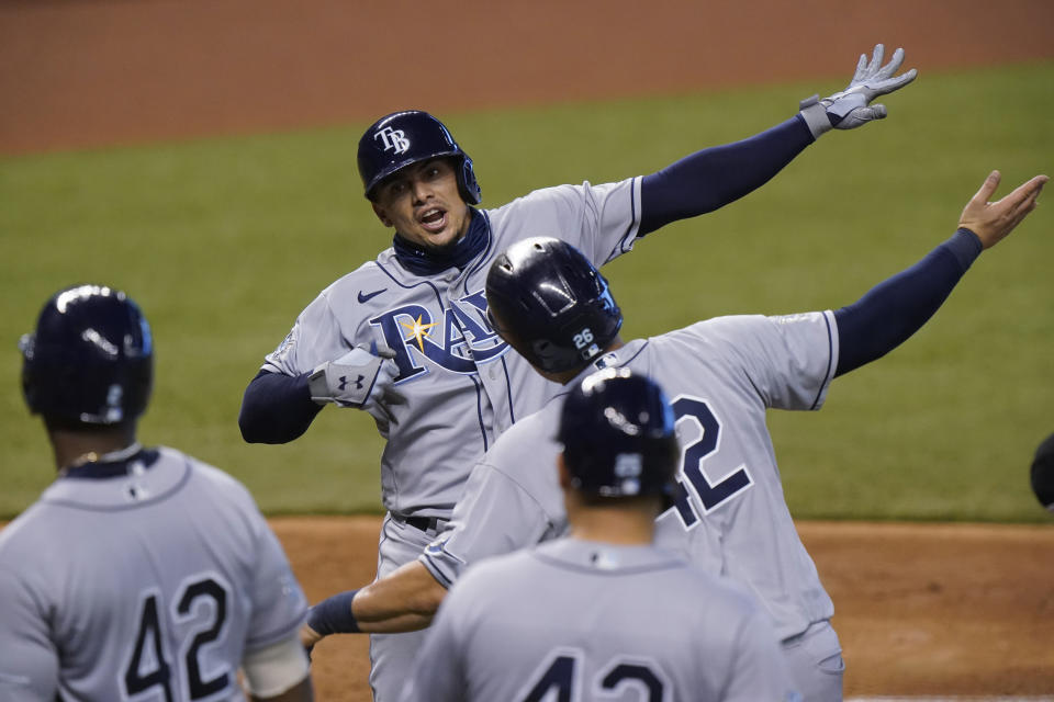 Tampa Bay Rays' Willy Adames, rear, celebrates with teammates after he hit a grand slam, also scoring Ji-Man Choi, Yandy Diaz and Yoshitomo Tsutsugo, during the fifth inning of a baseball game against the Miami Marlins, Sunday, Aug. 30, 2020, in Miami. (AP Photo/Wilfredo Lee)