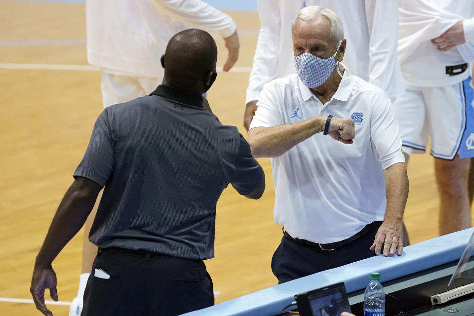 North Carolina coach Roy Williams, right, greets College of Charleston coach Earl Grant prior to an NCAA college basketball game in Chapel Hill, N.C., Wednesday, Nov. 25, 2020. (AP Photo/Gerry Broome)