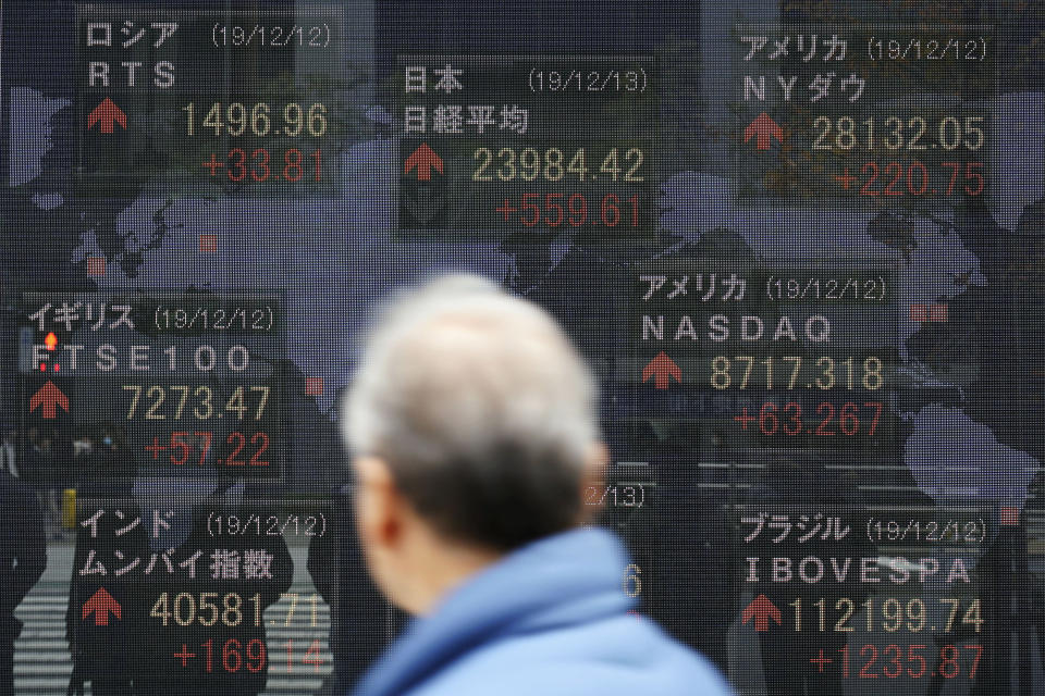 A man looks at an electronic stock board showing Japan's Nikkei 225 index and other country's index at a securities firm in Tokyo. A closely watched economic survey by the Bank of Japan showed sentiments among major manufacturers soured for the fourth straight quarter, the “tankan” survey released Friday, Dec. 13, 2019. A trade war between the U.S. and China crimped trade and growth. Japan’s growth is dependent on exports and any slowdown in pan-Pacific trade hurts company sentiments. (AP Photo/Eugene Hoshiko)