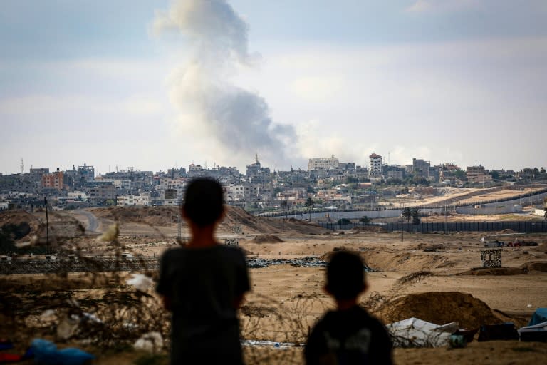 Boys watch smoke billowing during Israeli strikes east of Rafah in the southern Gaza Strip on May 13, 2024 (-)