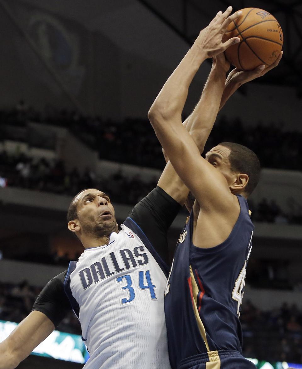 New Orleans Pelicans' forward Alexis Ajinca, right, attempts to shoot as Dallas Mavericks Brandan Wright (34) defends during the first half of an NBA basketball game on Wednesday, Feb. 26, 2014, in Dallas. (AP Photo/Brandon Wade)